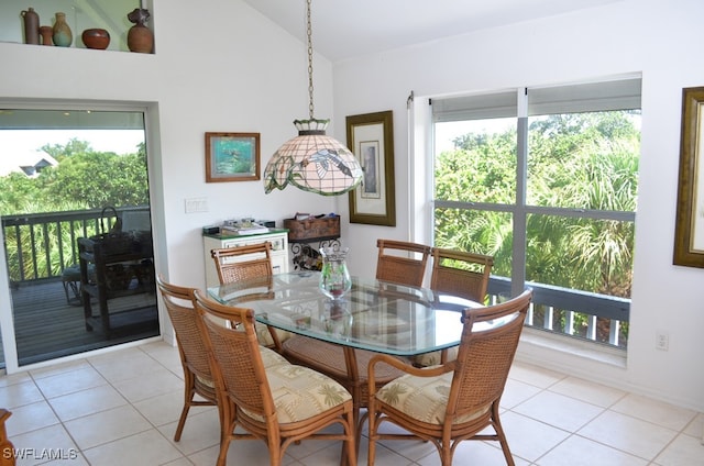 dining space featuring lofted ceiling, a healthy amount of sunlight, and light tile patterned floors