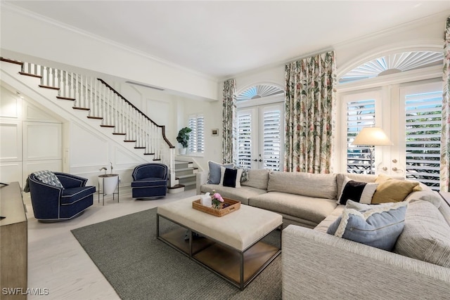 living room featuring crown molding, plenty of natural light, and french doors