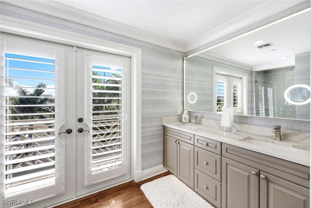 bathroom with vanity, hardwood / wood-style flooring, plenty of natural light, and ornamental molding