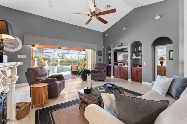 tiled living room with built in shelves, high vaulted ceiling, and ceiling fan