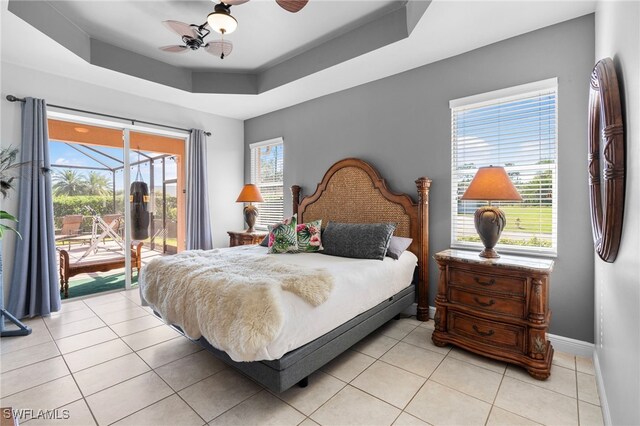 tiled bedroom featuring access to outside, a raised ceiling, and ceiling fan