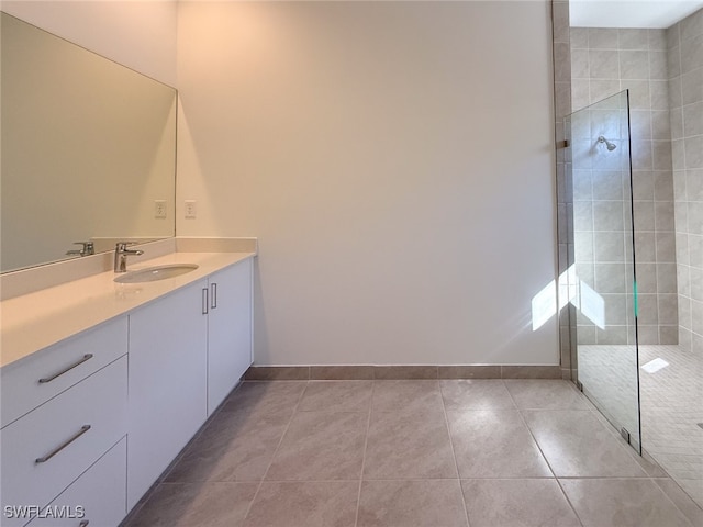 bathroom with tile patterned floors, vanity, and a tile shower