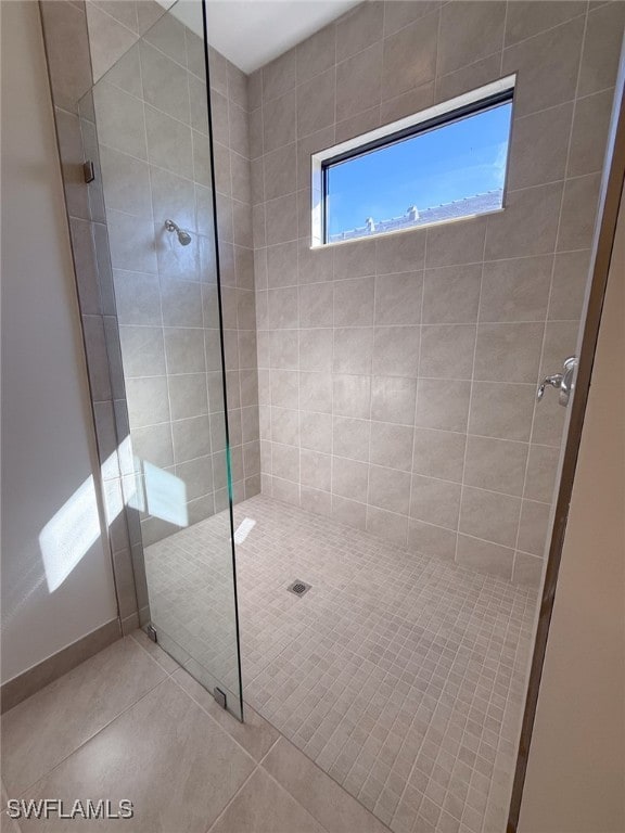 bathroom with tile patterned flooring and a tile shower