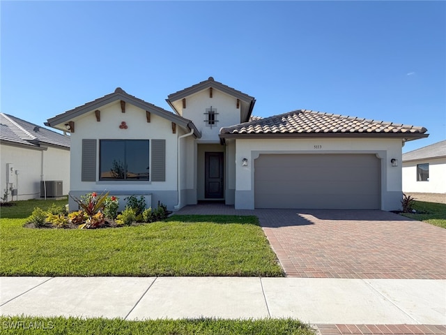 mediterranean / spanish-style house featuring a garage, a front lawn, and cooling unit