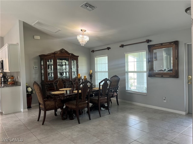 tiled dining room with an inviting chandelier