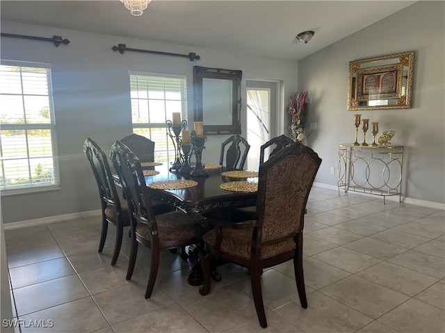 dining room with a wealth of natural light, light tile patterned floors, and vaulted ceiling