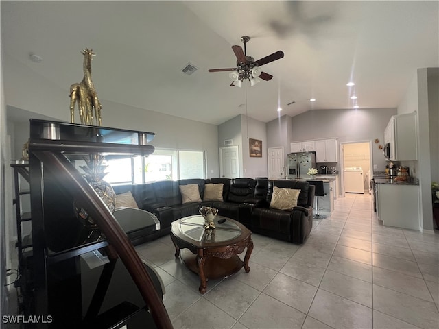 living room with ceiling fan, light tile patterned flooring, washer / dryer, and high vaulted ceiling