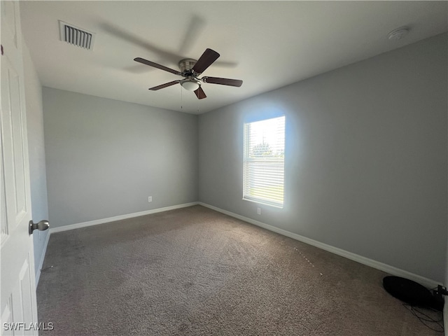 empty room featuring dark carpet and ceiling fan