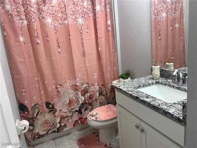 bathroom featuring tile patterned flooring, vanity, and toilet