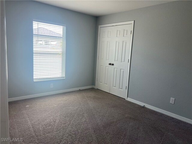 unfurnished bedroom with carpet floors and a closet