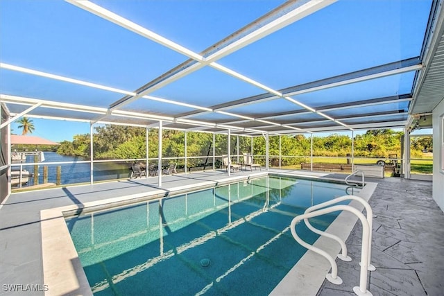 view of pool featuring glass enclosure, a patio area, and a water view