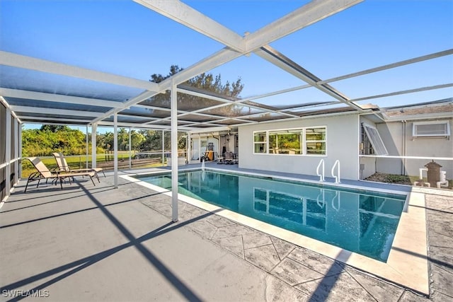 view of swimming pool with a wall mounted air conditioner, a patio area, and a lanai