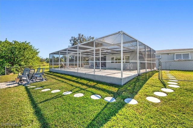 rear view of property with a yard, a patio, glass enclosure, and a swimming pool