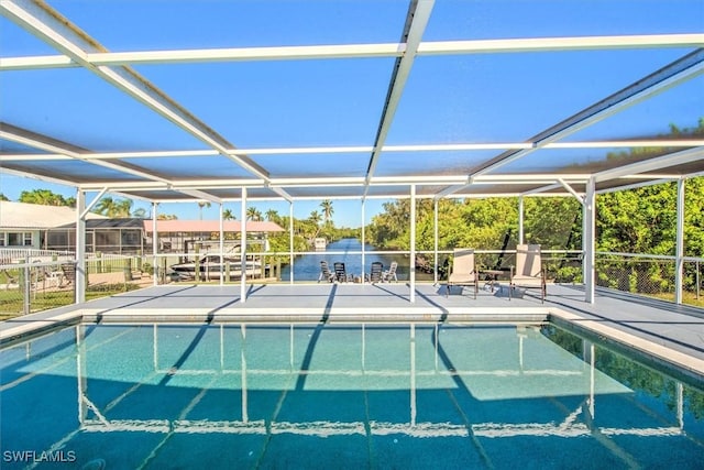 view of pool with a patio, a water view, and glass enclosure