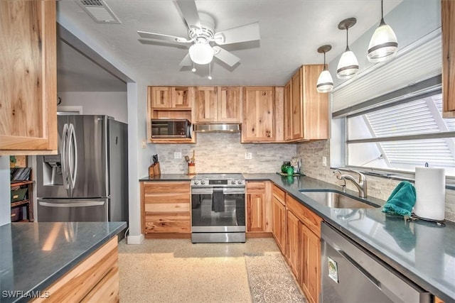 kitchen featuring tasteful backsplash, stainless steel appliances, ceiling fan, sink, and hanging light fixtures