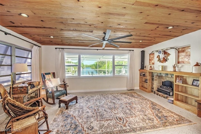 living area with a fireplace, carpet, ceiling fan, and wooden ceiling