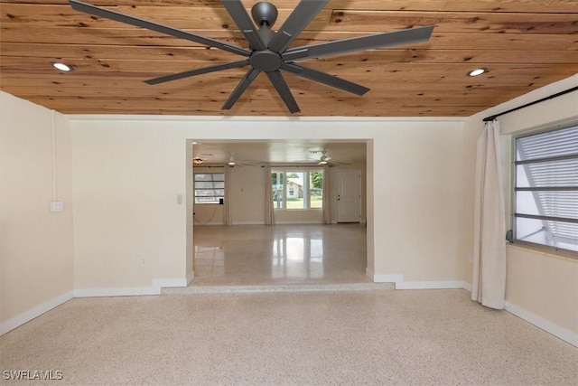 349 Coral Dr, Fort Myers, FL 33905 - empty room featuring wooden ceiling, a ceiling fan, baseboards, and dark aggregate flooring