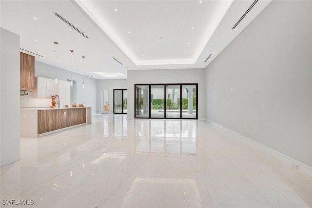 unfurnished living room with a tray ceiling