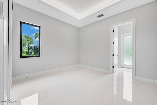 empty room featuring a raised ceiling