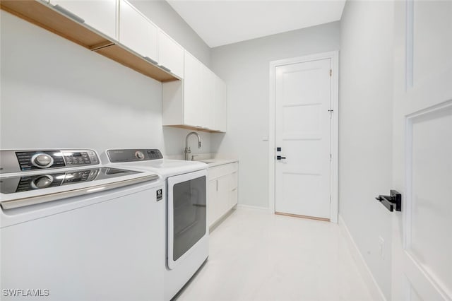 washroom featuring washer and dryer, cabinets, and sink