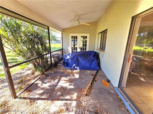 unfurnished sunroom with ceiling fan, french doors, and vaulted ceiling