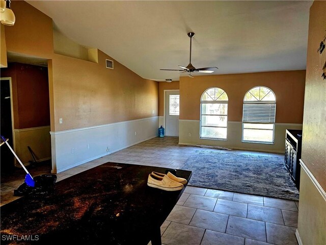 unfurnished living room featuring vaulted ceiling, ceiling fan, and light tile patterned flooring