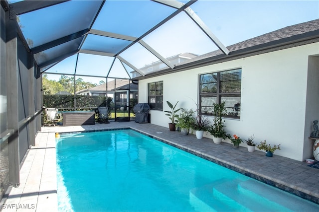 view of swimming pool with a lanai and a grill