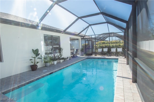 view of swimming pool featuring a lanai and a patio area