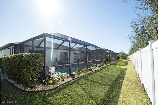 view of swimming pool with a lawn and a lanai