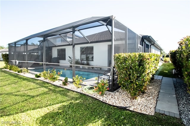 view of swimming pool featuring glass enclosure and a yard