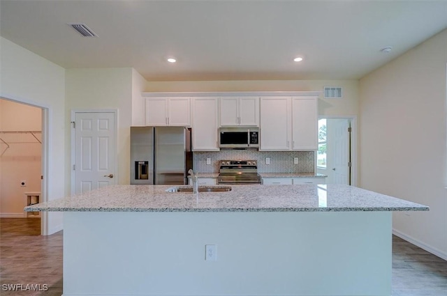 kitchen with a kitchen island with sink, sink, white cabinets, and stainless steel appliances