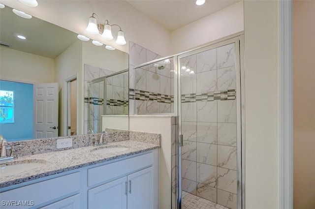 bathroom with a shower with door and vanity