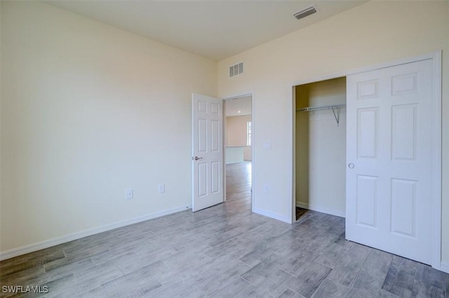 unfurnished bedroom with light hardwood / wood-style flooring and a closet