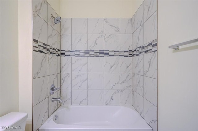 bathroom with tiled shower / bath and toilet