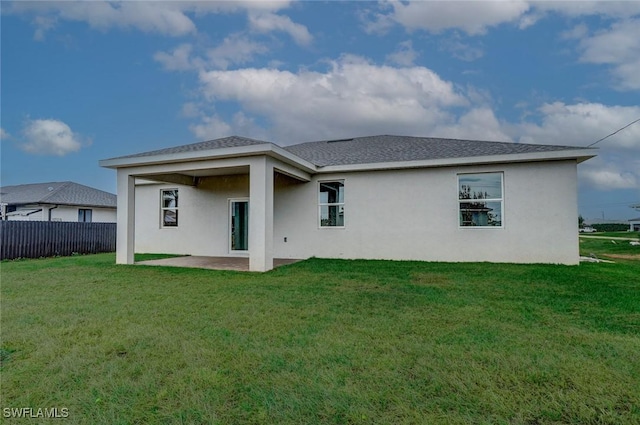 rear view of house with a patio and a lawn