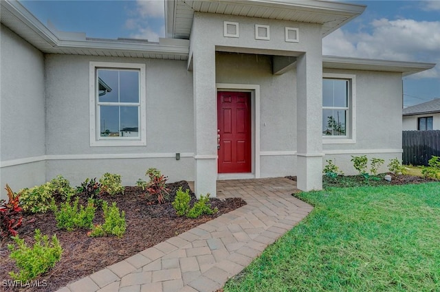 view of exterior entry with a lawn