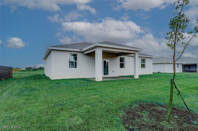 back of property featuring a yard and a patio area