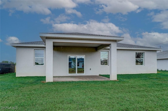 rear view of property featuring a patio area and a yard