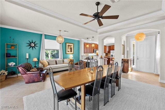 19550 Casa Bendita Ct, Estero, FL 33967 - dining room featuring light tile patterned floors, ornamental molding, arched walkways, a ceiling fan, and a raised ceiling