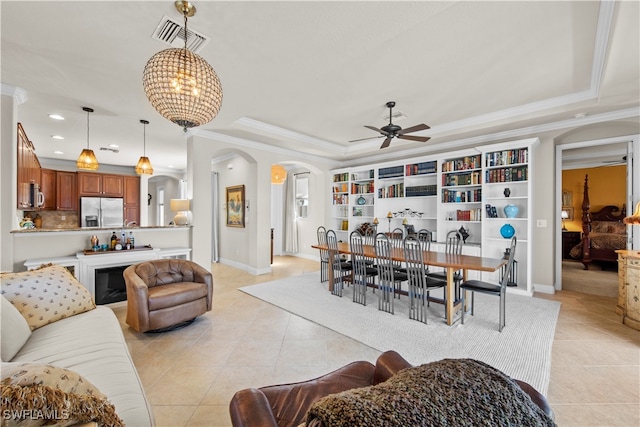 living room with ornamental molding, light tile patterned flooring, ceiling fan, and a tray ceiling