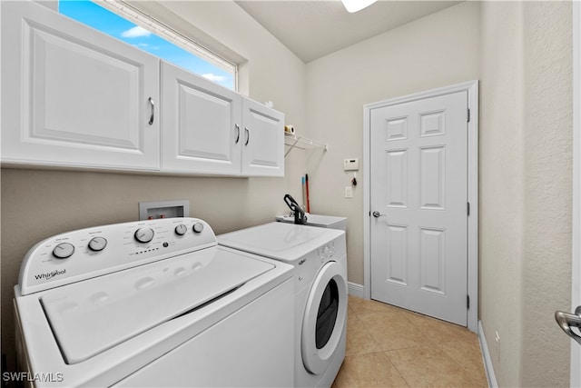 laundry area with cabinets, washing machine and dryer, and light tile patterned floors