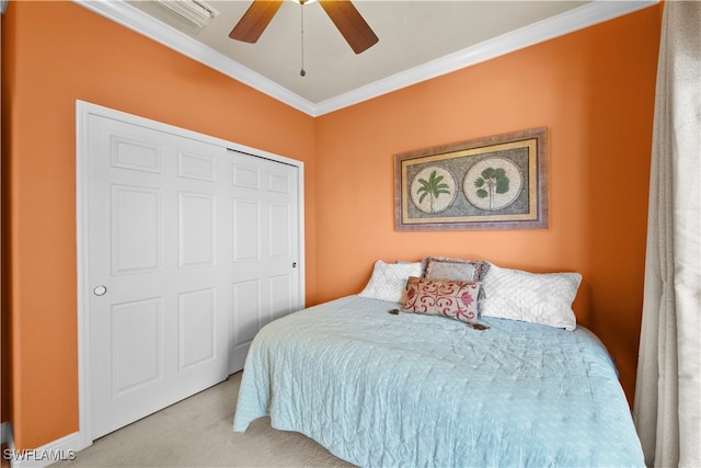 carpeted bedroom with crown molding, ceiling fan, and a closet