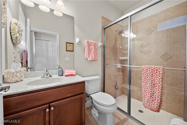 bathroom featuring vanity, toilet, and a shower with door