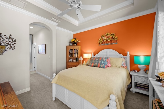 carpeted bedroom featuring a tray ceiling, crown molding, and ceiling fan