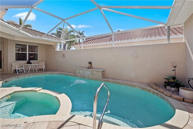 19550 Casa Bendita Ct, Estero, FL 33967 - view of swimming pool with a pool with connected hot tub, glass enclosure, and a patio