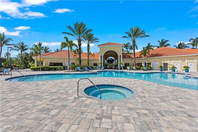 view of pool with a patio area and a hot tub