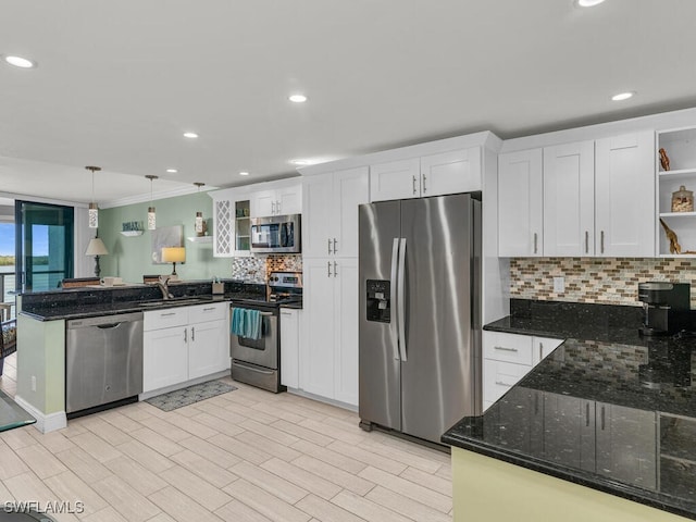 kitchen featuring pendant lighting, white cabinets, sink, dark stone countertops, and stainless steel appliances