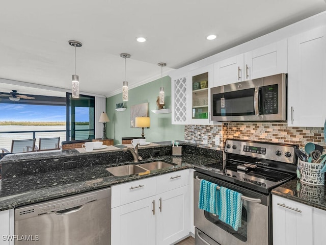 kitchen with sink, white cabinets, decorative light fixtures, and appliances with stainless steel finishes