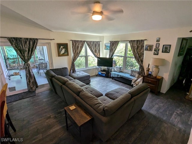 living room with lofted ceiling, ceiling fan, and dark wood-type flooring