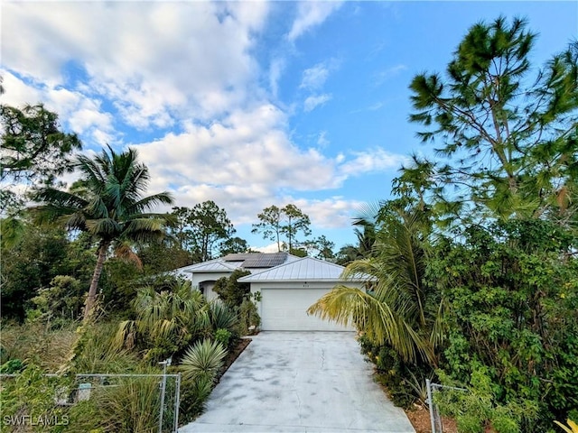 obstructed view of property featuring solar panels and a garage